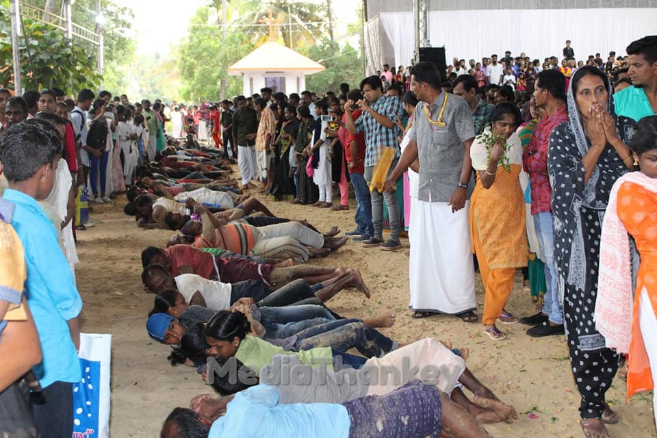 Pilgrims rolling in the sacred churchyard sand — Good Friday tradition at Thankey
